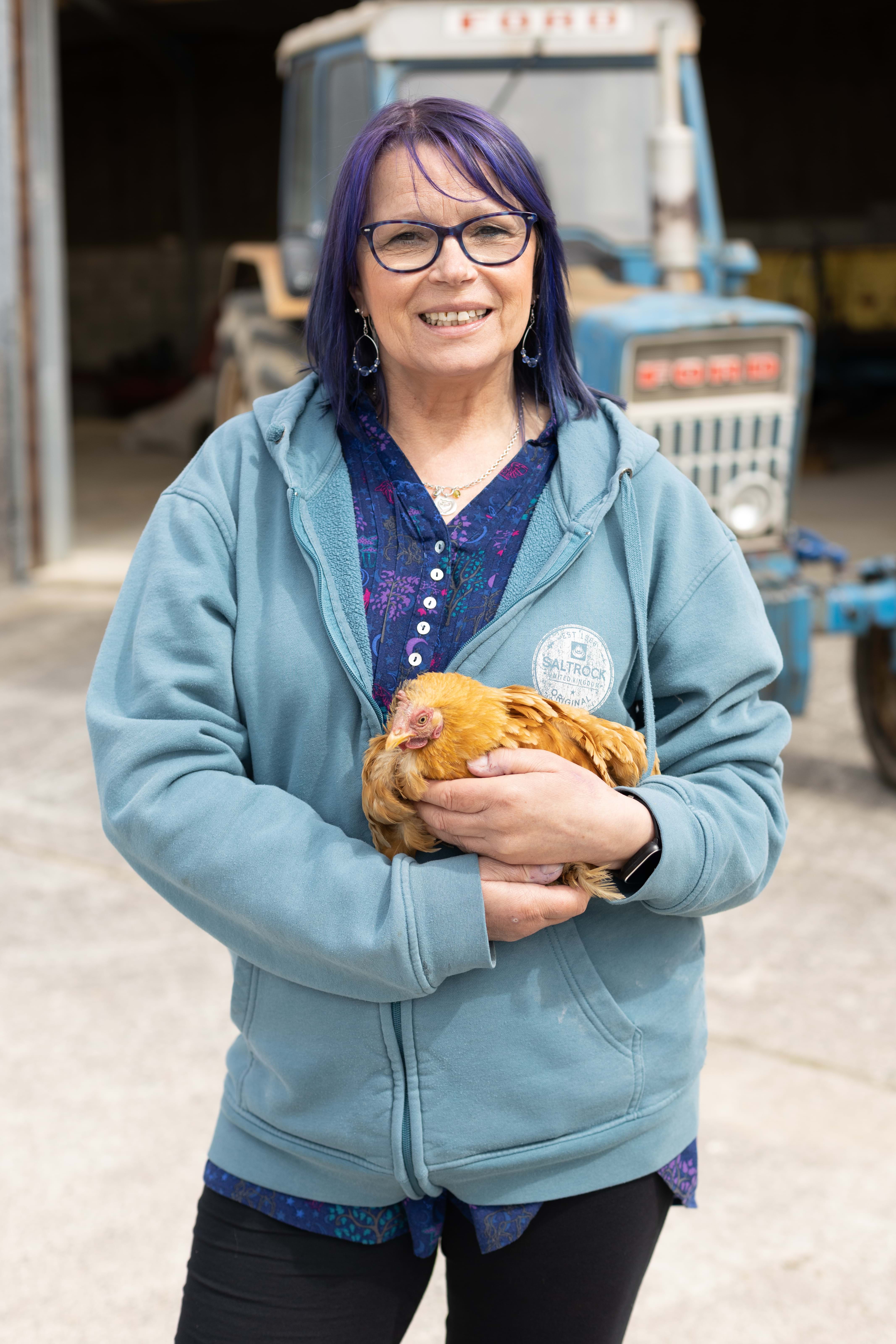An image of a woman holding a chicken